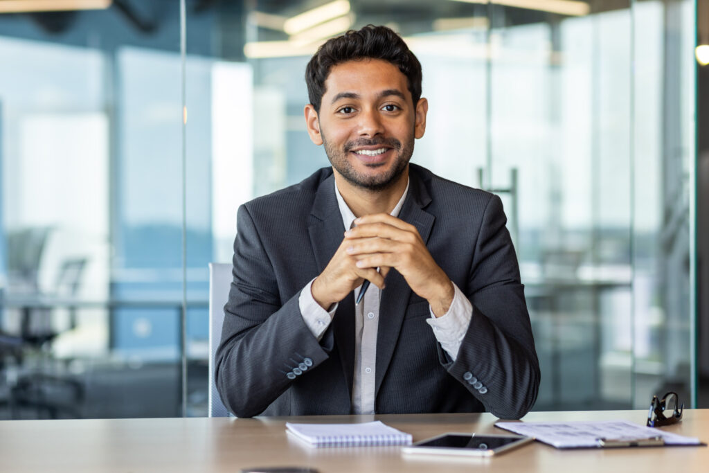 Smiling businessman at office desk with papers